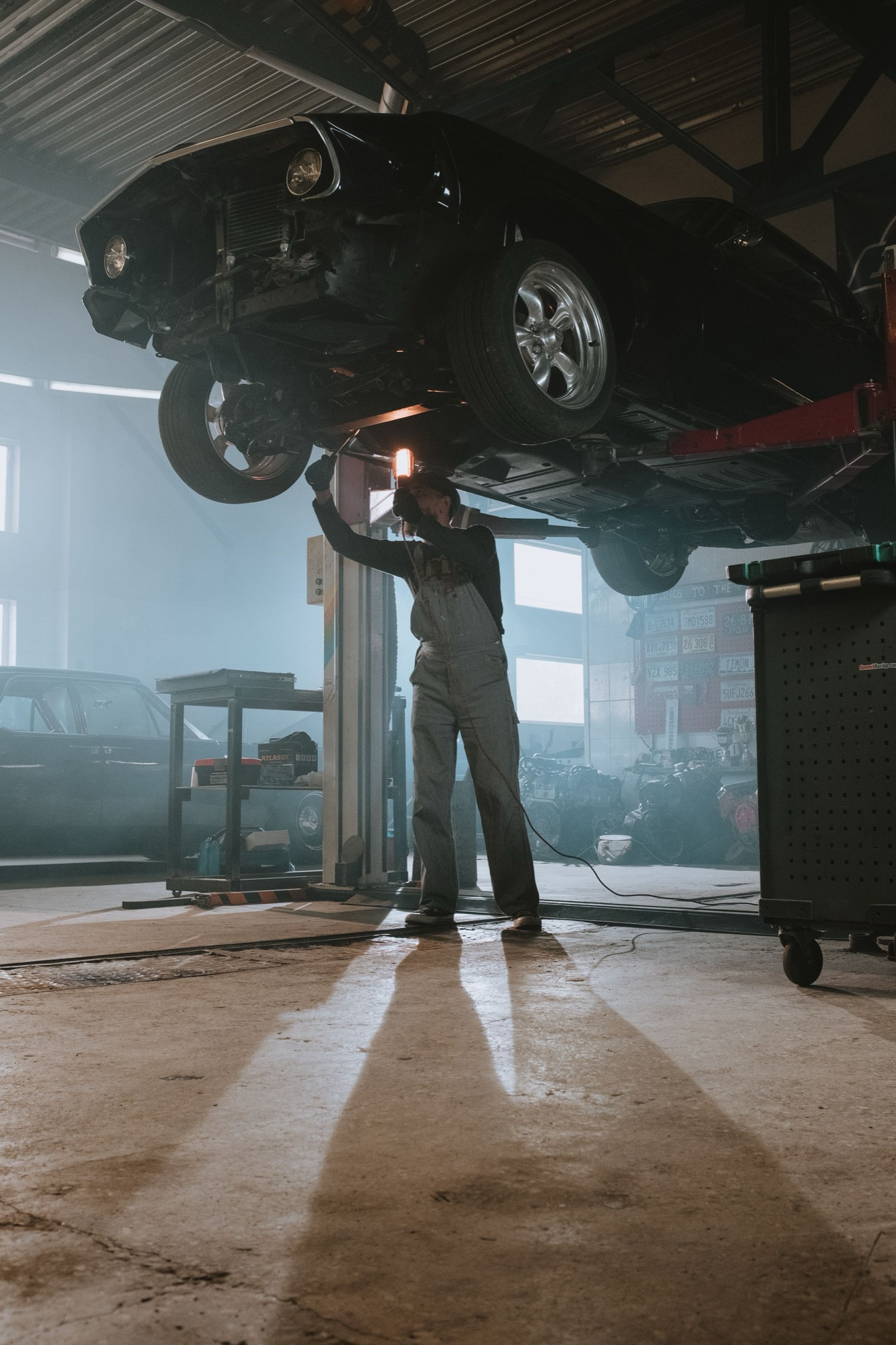 A repair bay with a vehicle on the lift.