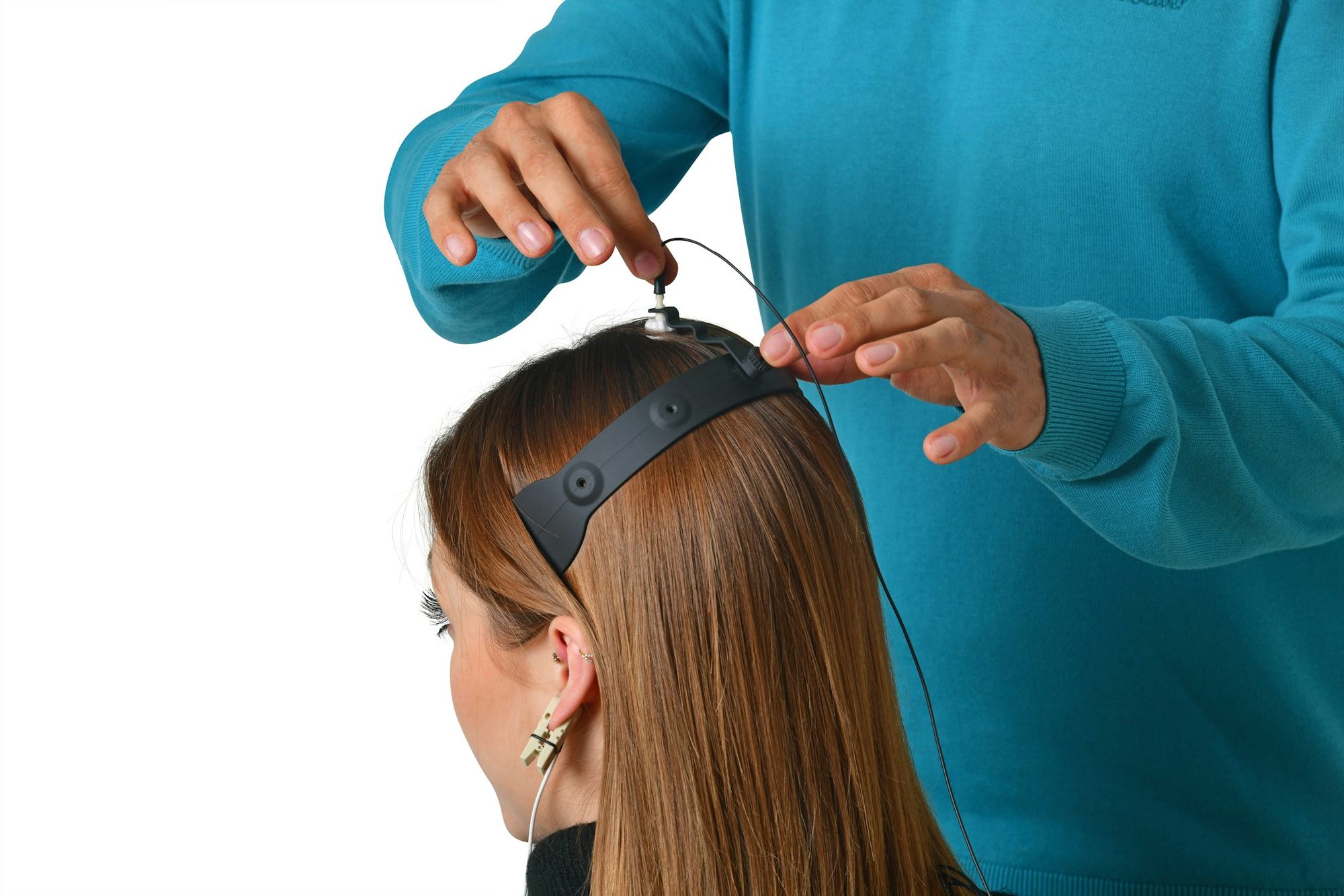 A technician placing EEG electrodes on a person's head.