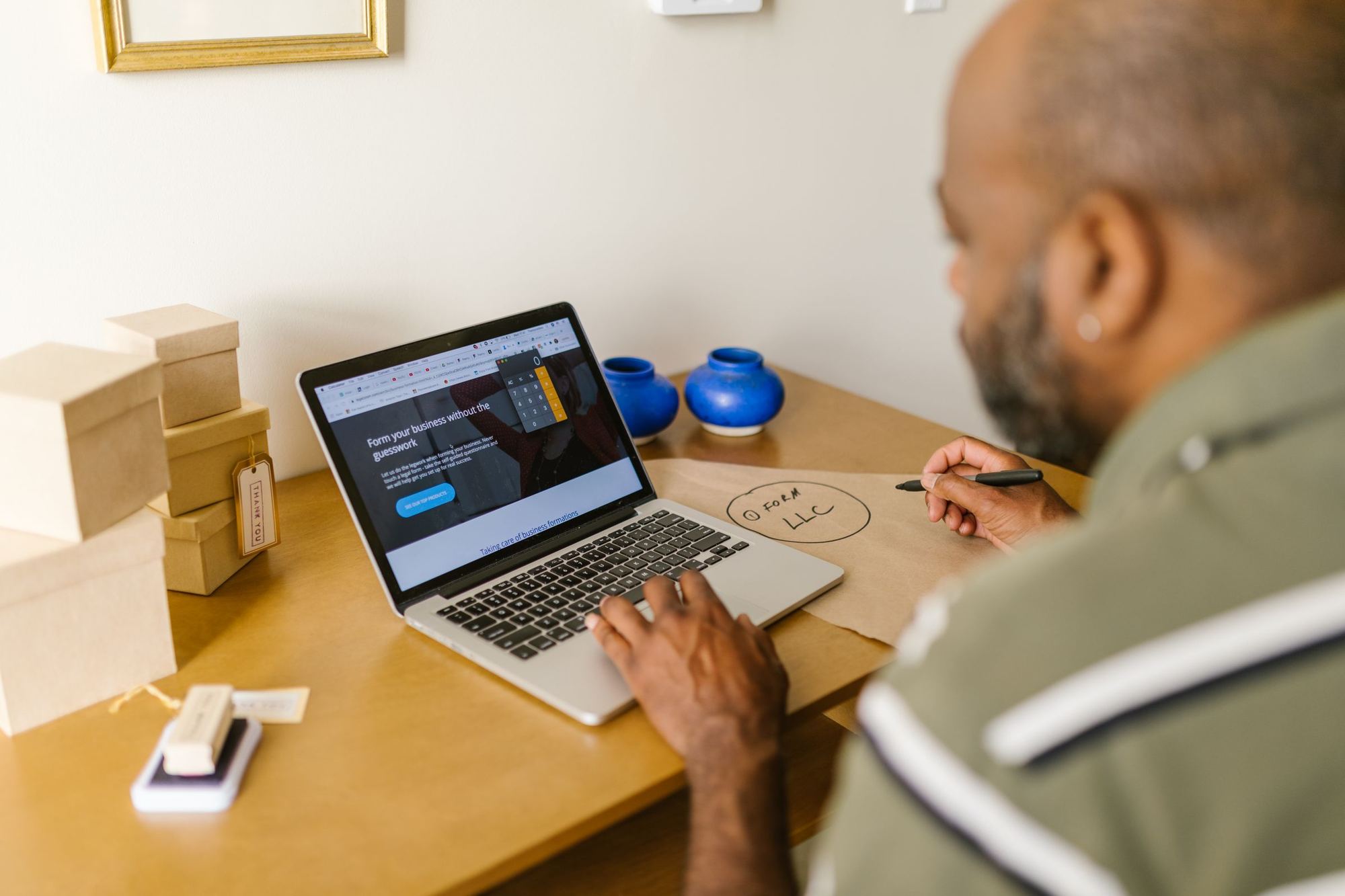 A business owner at a desk working on a laptop.