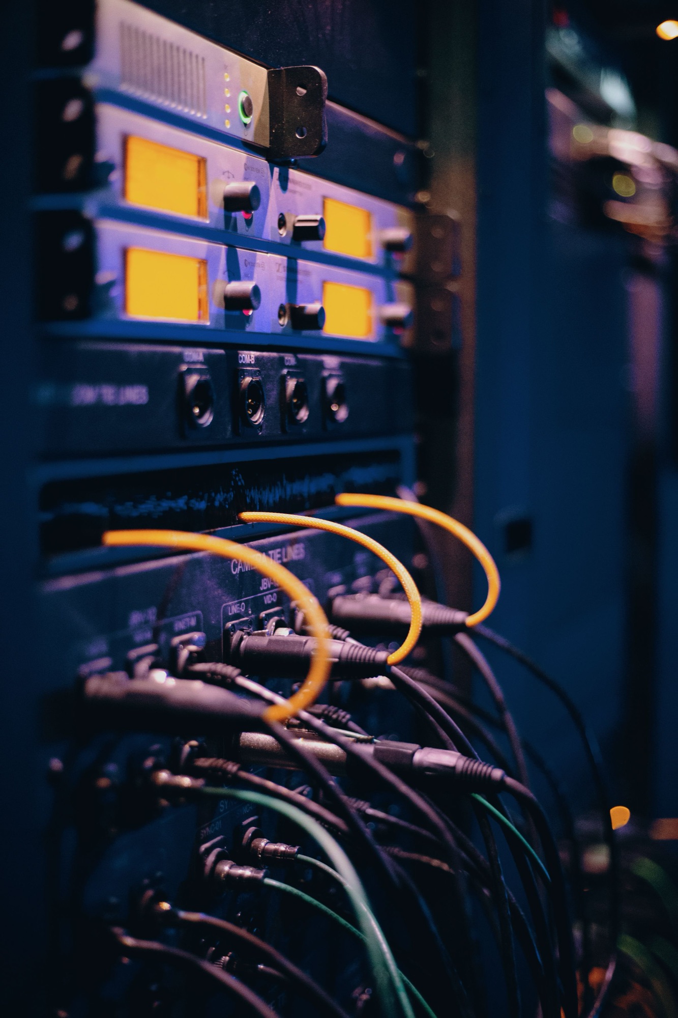 Network cables lit amber in a dark server rack. Illustrative photograph.