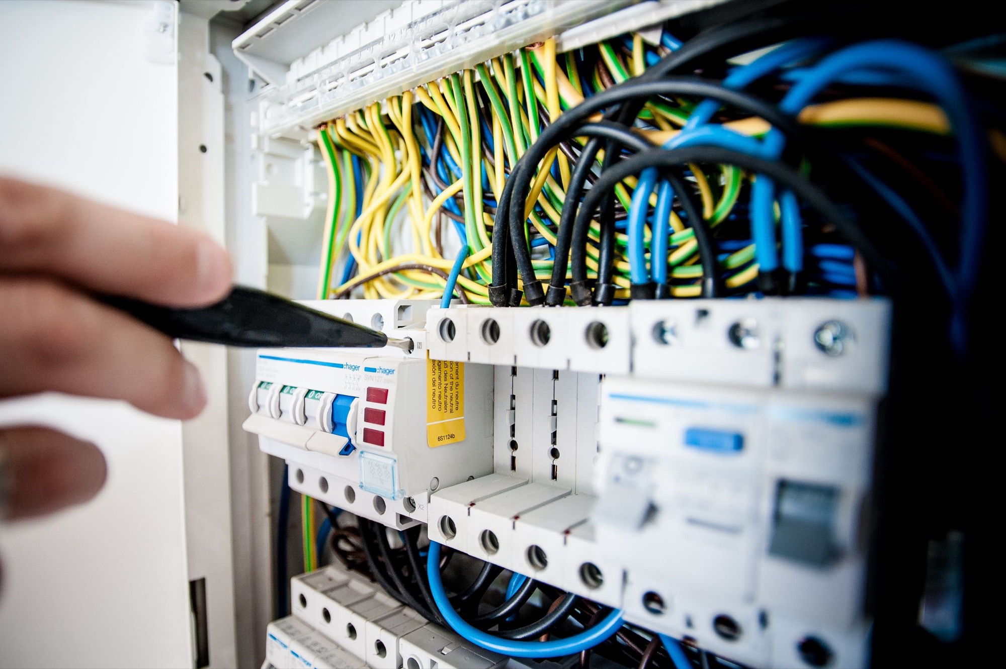 A hand wiring a switchboard.